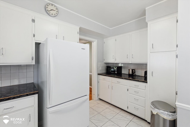 501 Lafayette St, Flint, MI 48503 - kitchen featuring freestanding refrigerator, decorative backsplash, white cabinetry, and black microwave