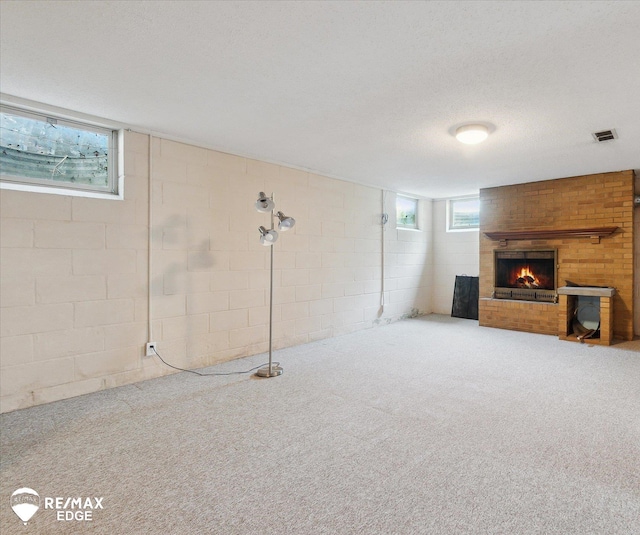 501 Lafayette St, Flint, MI 48503 - basement featuring a brick fireplace, plenty of natural light, concrete block wall, carpet, and a textured ceiling
