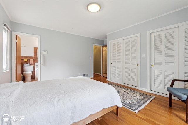 501 Lafayette St, Flint, MI 48503 - bedroom featuring two closets, wood finished floors, and ensuite bath