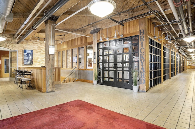 940 Monroe Ave NW Unit 416, Grand Rapids, MI 49503 - miscellaneous room with tile patterned floors, wood walls, and brick wall