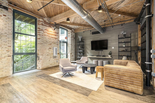 940 Monroe Ave NW Unit 416, Grand Rapids, MI 49503 - living area featuring a wooden ceiling with exposed beams, brick wall, wood finished floors, and high vaulted ceiling