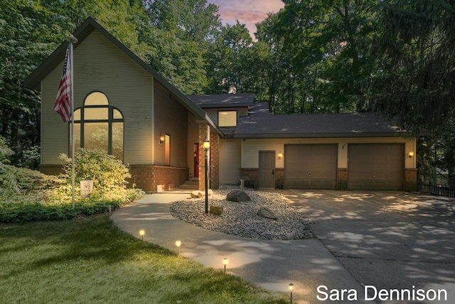 1026 Alan St, Fremont, MI 49412 - view of front of home featuring a garage, brick siding, and concrete driveway