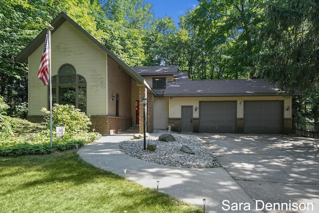 1026 Alan St, Fremont, MI 49412 - view of front facade with a garage, brick siding, and concrete driveway