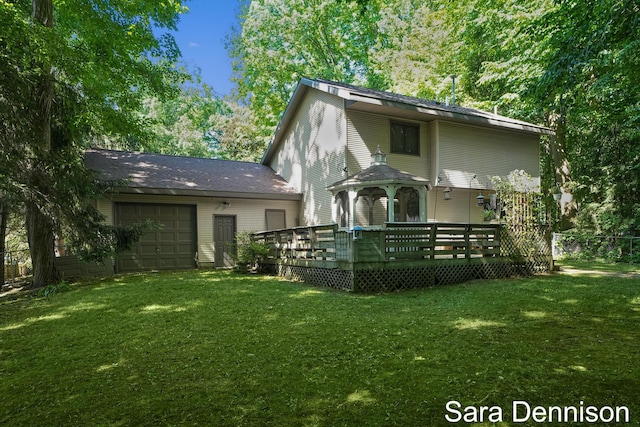 1026 Alan St, Fremont, MI 49412 - back of house featuring a garage, a lawn, and a wooden deck