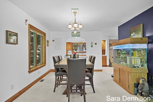 1026 Alan St, Fremont, MI 49412 - dining space featuring light colored carpet, a chandelier, arched walkways, and healthy amount of natural light