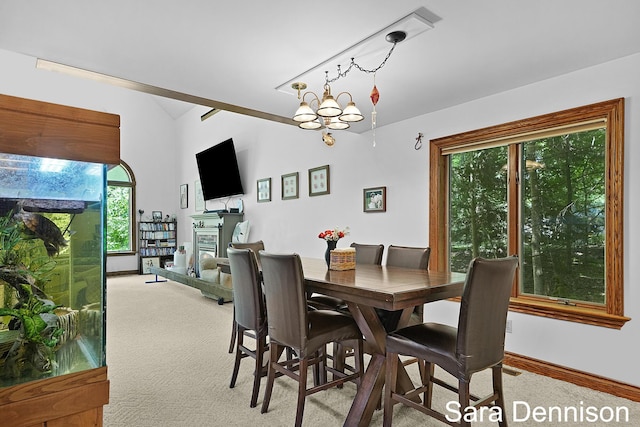 1026 Alan St, Fremont, MI 49412 - dining room with light colored carpet, vaulted ceiling, and a glass covered fireplace