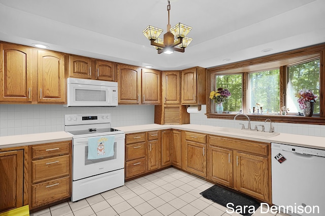1026 Alan St, Fremont, MI 49412 - kitchen with white appliances, tasteful backsplash, light countertops, brown cabinets, and recessed lighting