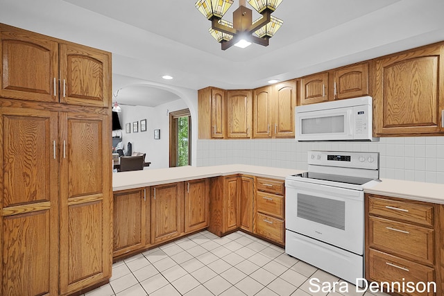 1026 Alan St, Fremont, MI 49412 - kitchen featuring white appliances, brown cabinetry, light countertops, decorative backsplash, and recessed lighting