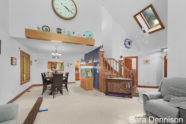 1026 Alan St, Fremont, MI 49412 - dining room with high vaulted ceiling, stairs, light colored carpet, a chandelier, and a skylight