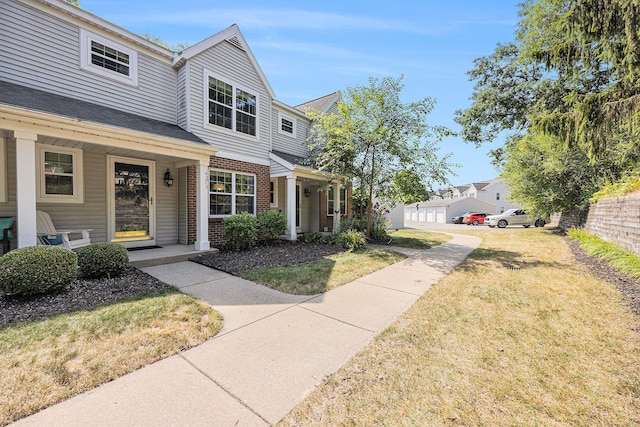 4273 Sawkaw Dr NE, Grand Rapids, MI 49525 - view of front of home with brick siding, covered porch, and a front lawn