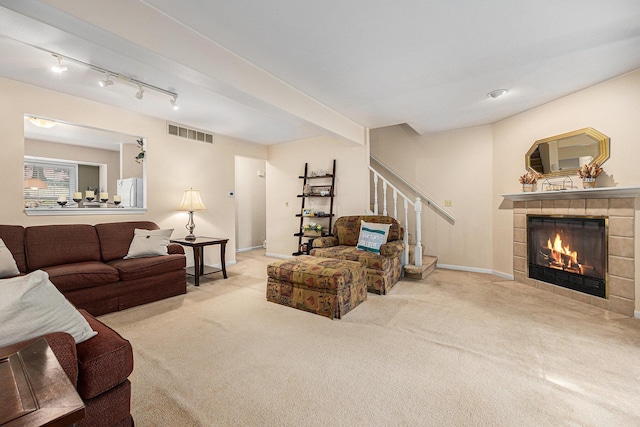 4273 Sawkaw Dr NE, Grand Rapids, MI 49525 - carpeted living room with a fireplace, stairs, and track lighting