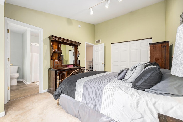 4273 Sawkaw Dr NE, Grand Rapids, MI 49525 - bedroom featuring light carpet, a closet, rail lighting, connected bathroom, and a towering ceiling