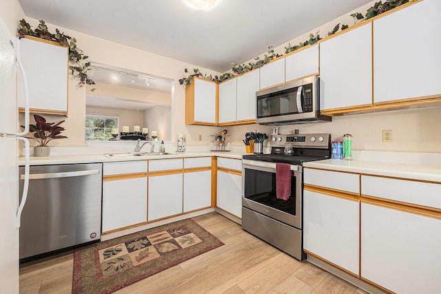 4273 Sawkaw Dr NE, Grand Rapids, MI 49525 - kitchen featuring appliances with stainless steel finishes, light wood-type flooring, light countertops, and white cabinetry