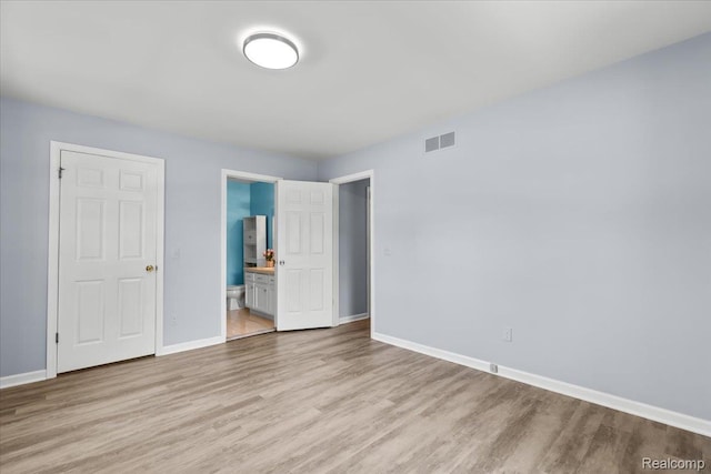24690 Bashian Dr, Novi, MI 48375 - unfurnished bedroom featuring wood finished floors and connected bathroom