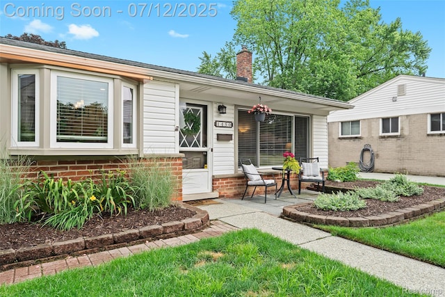1450 N Stephen Ave, Clawson, MI 48017 - view of exterior entry with a chimney and covered porch