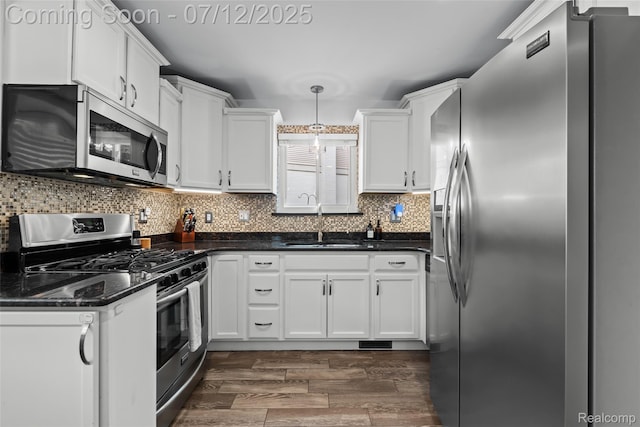 1450 N Stephen Ave, Clawson, MI 48017 - kitchen with appliances with stainless steel finishes, white cabinets, decorative backsplash, and decorative light fixtures