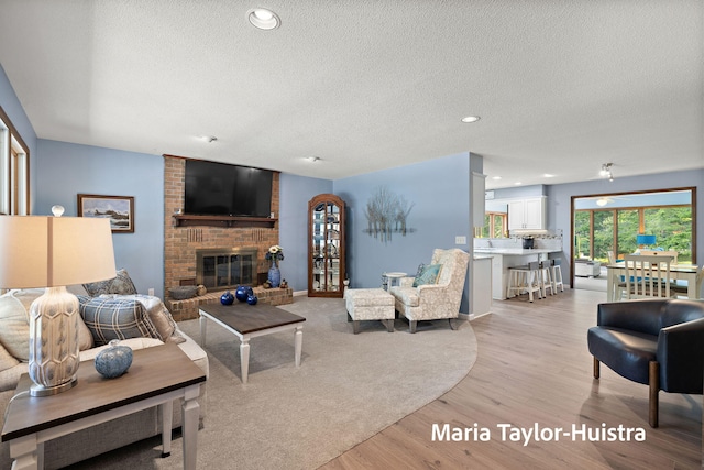 16205 Suffolk Dr, Spring Lake, MI 49456 - living room featuring a textured ceiling, a fireplace, light wood finished floors, and recessed lighting