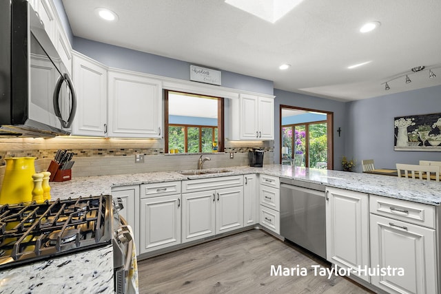 16205 Suffolk Dr, Spring Lake, MI 49456 - kitchen featuring stainless steel appliances, white cabinets, backsplash, light wood-style flooring, and a peninsula