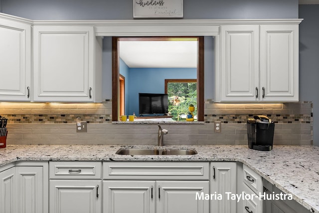 16205 Suffolk Dr, Spring Lake, MI 49456 - kitchen with white cabinets, decorative backsplash, and light stone counters