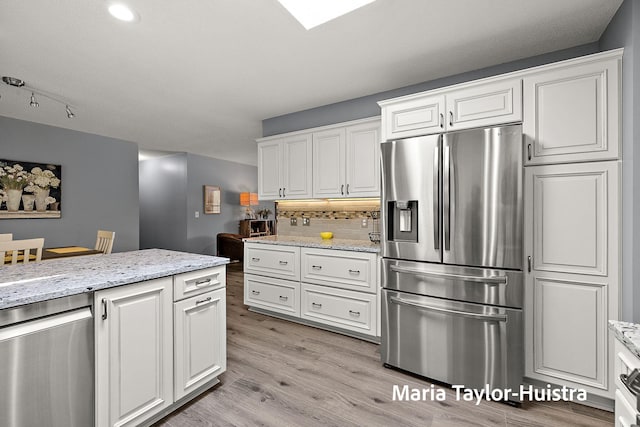 16205 Suffolk Dr, Spring Lake, MI 49456 - kitchen with stainless steel appliances, backsplash, white cabinets, light wood-style flooring, and light stone counters
