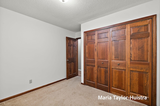 16205 Suffolk Dr, Spring Lake, MI 49456 - unfurnished bedroom with light colored carpet, a closet, and a textured ceiling