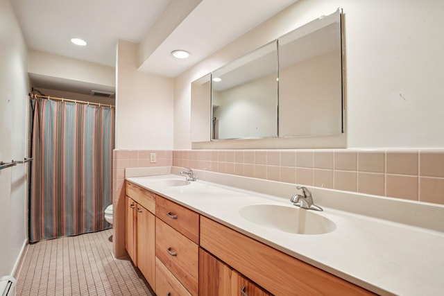 2373 Belgrade Notch St, Ann Arbor, MI 48103 - bathroom with a baseboard radiator, double vanity, tile walls, tile patterned floors, and recessed lighting