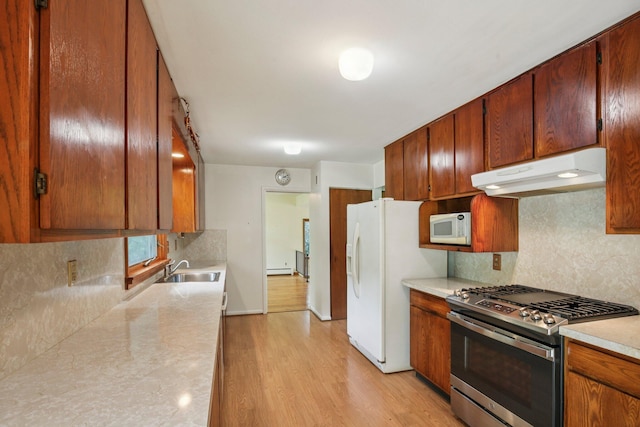 2373 Belgrade Notch St, Ann Arbor, MI 48103 - kitchen featuring white appliances, under cabinet range hood, decorative backsplash, light countertops, and light wood-style flooring