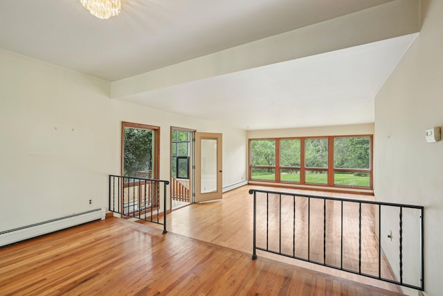 2373 Belgrade Notch St, Ann Arbor, MI 48103 - empty room with baseboard heating, wood finished floors, and a chandelier