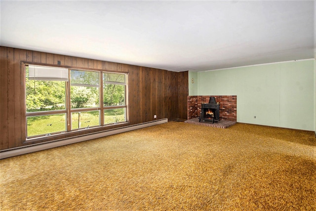 258 Division St, Eastlake, MI 49626 - unfurnished living room featuring a baseboard heating unit, wood walls, carpet flooring, and a wood stove