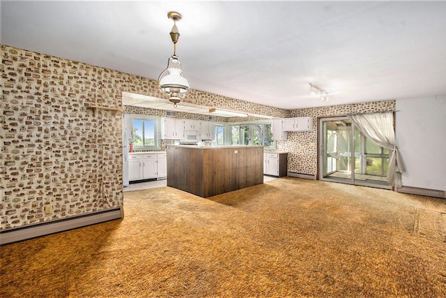 258 Division St, Eastlake, MI 49626 - kitchen with wallpapered walls, a baseboard radiator, healthy amount of natural light, white cabinets, and white microwave