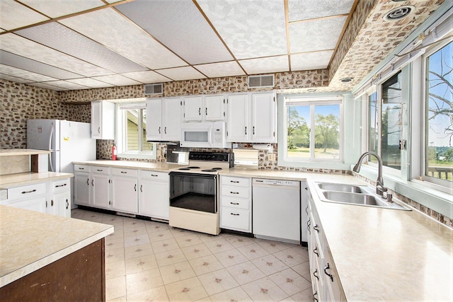 258 Division St, Eastlake, MI 49626 - kitchen featuring white appliances, light countertops, white cabinets, and wallpapered walls