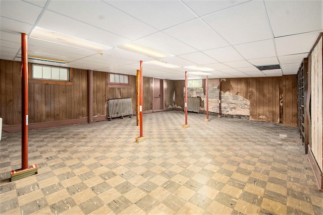 258 Division St, Eastlake, MI 49626 - below grade area featuring radiator, wooden walls, and a drop ceiling