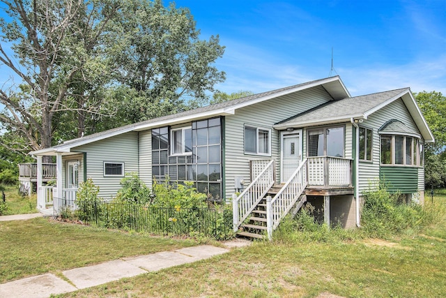 258 Division St, Eastlake, MI 49626 - view of front of property with a sunroom, a front lawn, and roof with shingles
