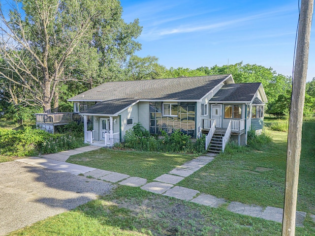 258 Division St, Eastlake, MI 49626 - view of front of house featuring a front lawn, a shingled roof, and a porch