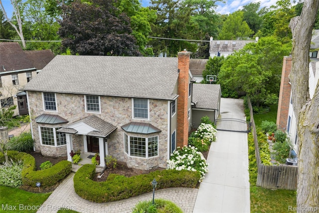 639 N Glenhurst Dr, Birmingham, MI 48009 - view of front facade with stone siding, roof with shingles, and a chimney