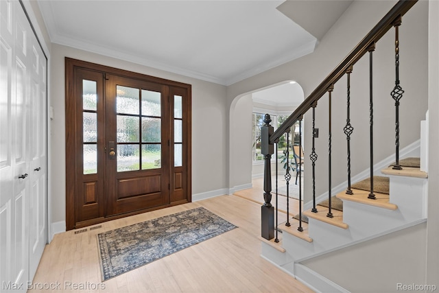 639 N Glenhurst Dr, Birmingham, MI 48009 - foyer entrance featuring wood finished floors, stairs, healthy amount of natural light, arched walkways, and ornamental molding