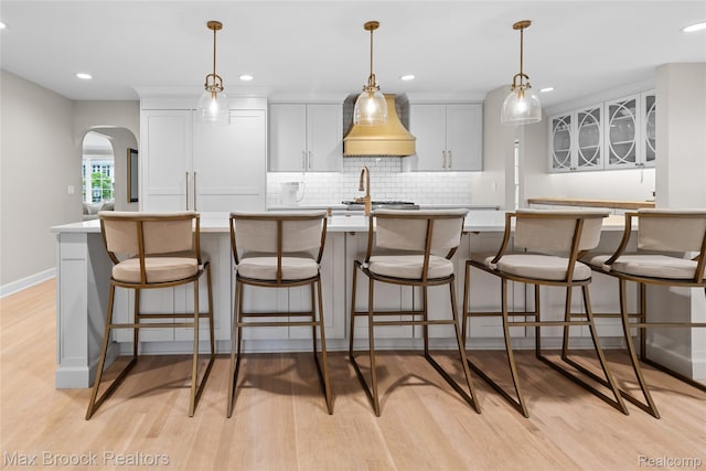 639 N Glenhurst Dr, Birmingham, MI 48009 - kitchen featuring arched walkways, light wood-style floors, decorative backsplash, light countertops, and recessed lighting