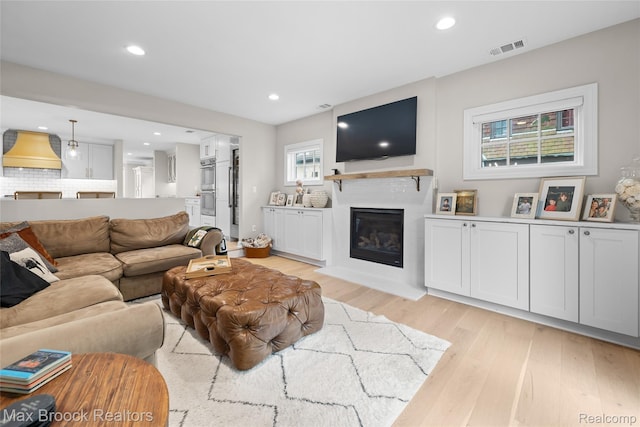 639 N Glenhurst Dr, Birmingham, MI 48009 - living area with light wood-style floors, a glass covered fireplace, and recessed lighting