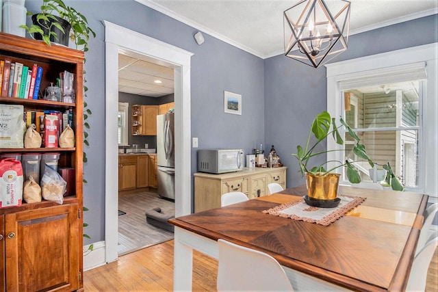 1200 Sherman St SE, Grand Rapids, MI 49506 - dining area featuring light wood-style floors, a chandelier, crown molding, and recessed lighting