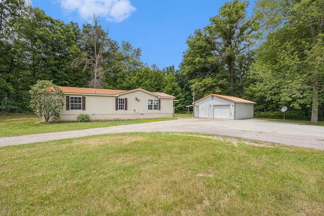 2141 S Parsons Ave, Fremont, MI 49412 - view of front of home featuring an outdoor structure, a garage, asphalt driveway, a front lawn, and view of wooded area
