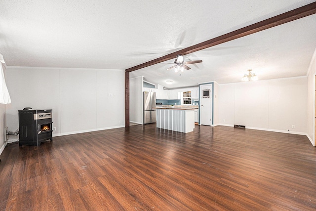 2141 S Parsons Ave, Fremont, MI 49412 - unfurnished living room with ceiling fan, dark wood-type flooring, and a wood stove