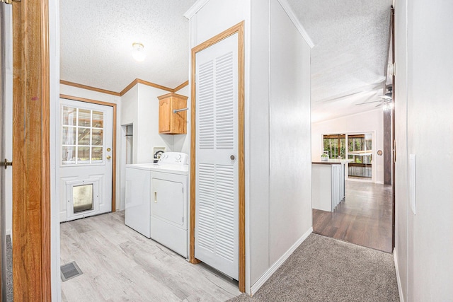 2141 S Parsons Ave, Fremont, MI 49412 - laundry area with cabinet space, a textured ceiling, washer and clothes dryer, light wood-style flooring, and crown molding