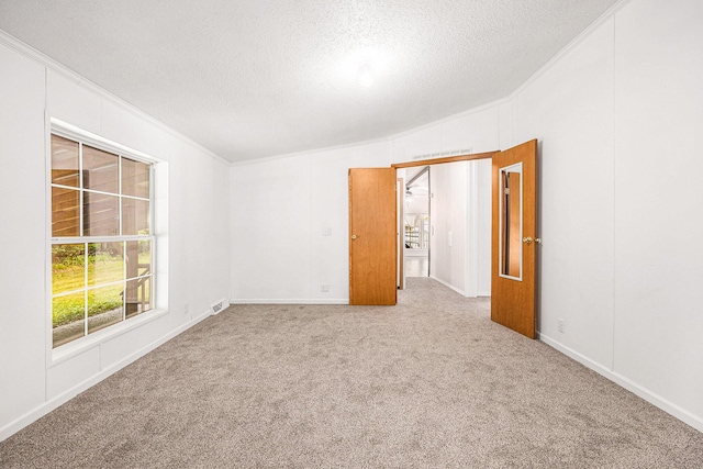 2141 S Parsons Ave, Fremont, MI 49412 - carpeted empty room featuring a textured ceiling, ornamental molding, and vaulted ceiling