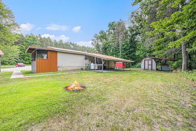 2141 S Parsons Ave, Fremont, MI 49412 - rear view of property featuring a storage shed, a yard, and an outdoor fire pit