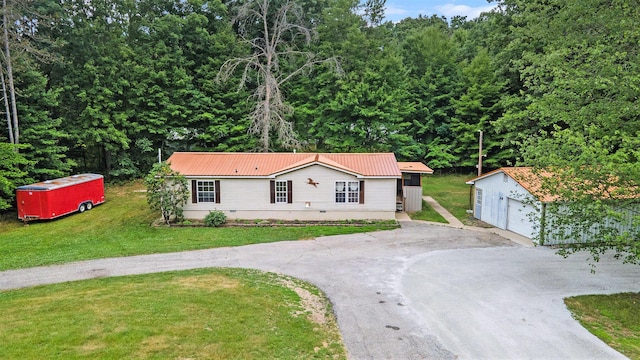 2141 S Parsons Ave, Fremont, MI 49412 - single story home featuring asphalt driveway, an outdoor structure, a garage, a front lawn, and a metal roof