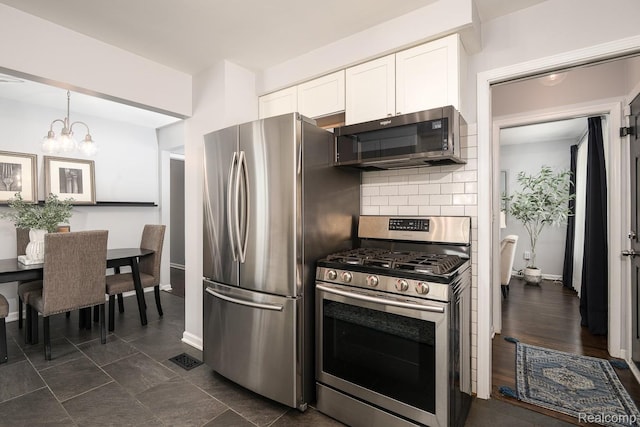 3410 N Main St, Royal Oak, MI 48073 - kitchen featuring stainless steel appliances, white cabinets, backsplash, a chandelier, and decorative light fixtures