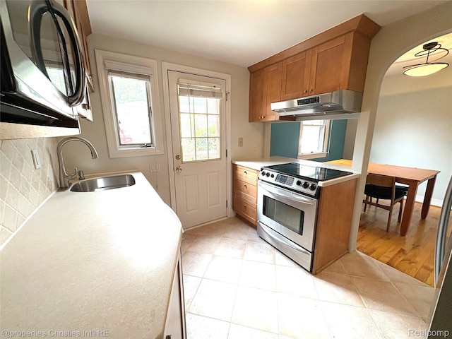 1983 Graefield Rd, Birmingham, MI 48009 - kitchen featuring under cabinet range hood, stainless steel electric range oven, brown cabinets, light countertops, and decorative backsplash