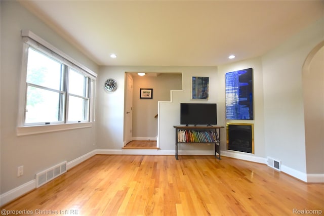 1983 Graefield Rd, Birmingham, MI 48009 - unfurnished living room featuring light wood-style floors, arched walkways, recessed lighting, and a fireplace