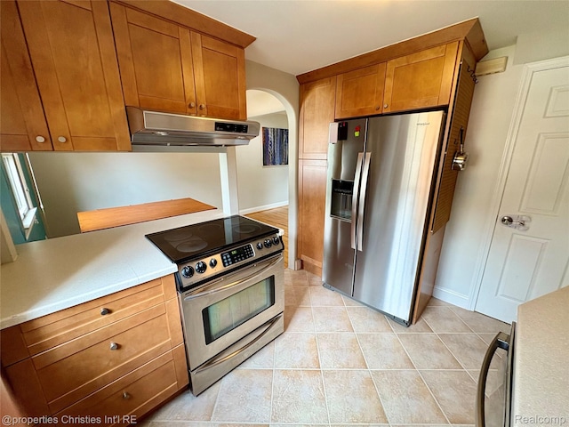 1983 Graefield Rd, Birmingham, MI 48009 - kitchen with appliances with stainless steel finishes, under cabinet range hood, arched walkways, and brown cabinetry