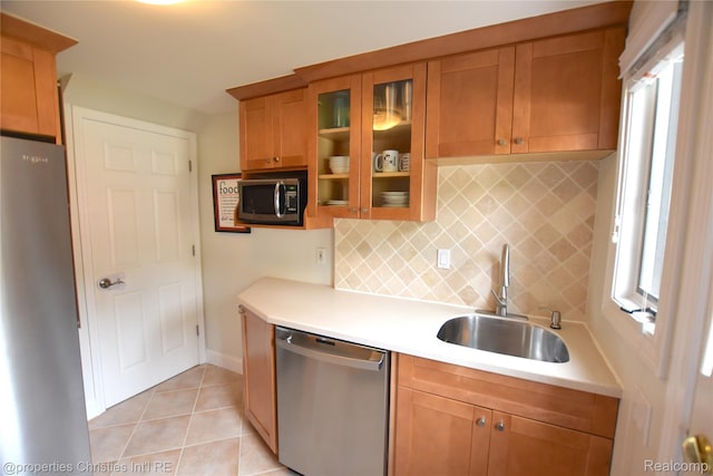 1983 Graefield Rd, Birmingham, MI 48009 - kitchen with appliances with stainless steel finishes, light countertops, decorative backsplash, glass insert cabinets, and light tile patterned flooring